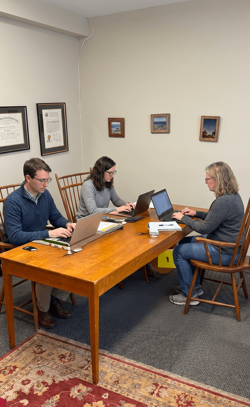 Professionals working at a shared table in a long-term private office